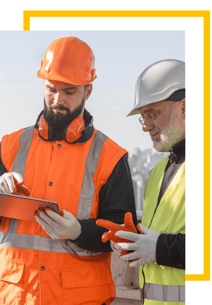 Dois trabalhadores atuando em uma construção verificando o andamento em um tablet